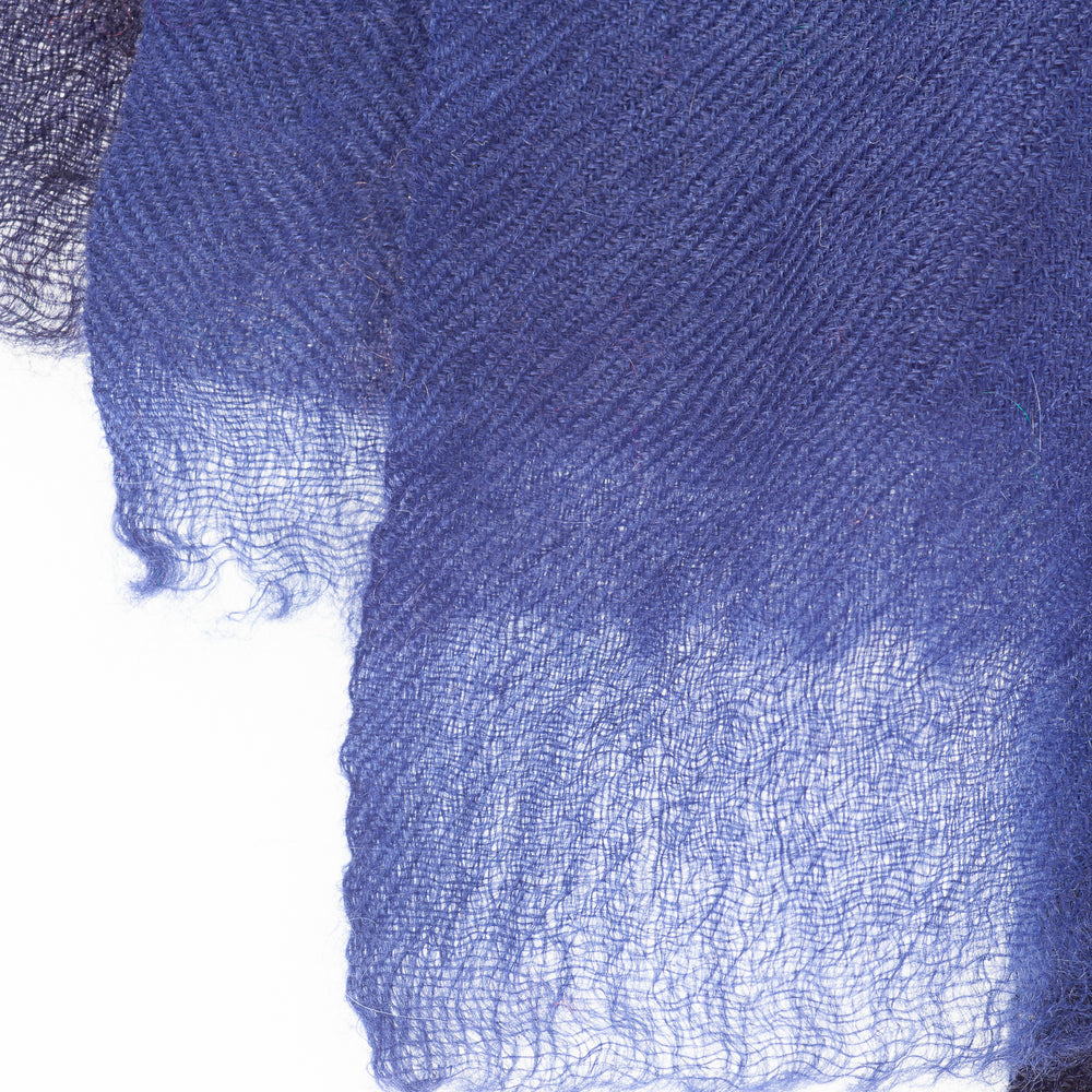 
                      
                        Nahaufnahme der feinen Kaschmirfaser des Schals „The Breeze – Ombré Indigo“; besonders weich, leicht und hochwertig verarbeitet.
                      
                    