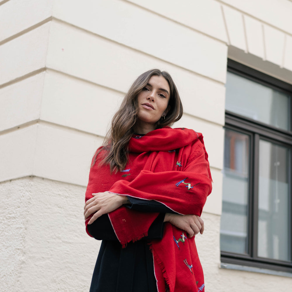 
                      
                        Model trägt den roten Pashmina Schal „The Adorned – Alpine Life“; handgefertigt aus Kaschmir mit alpinen Stickmotiven, Ausdruck von Eleganz und Wärm
                      
                    