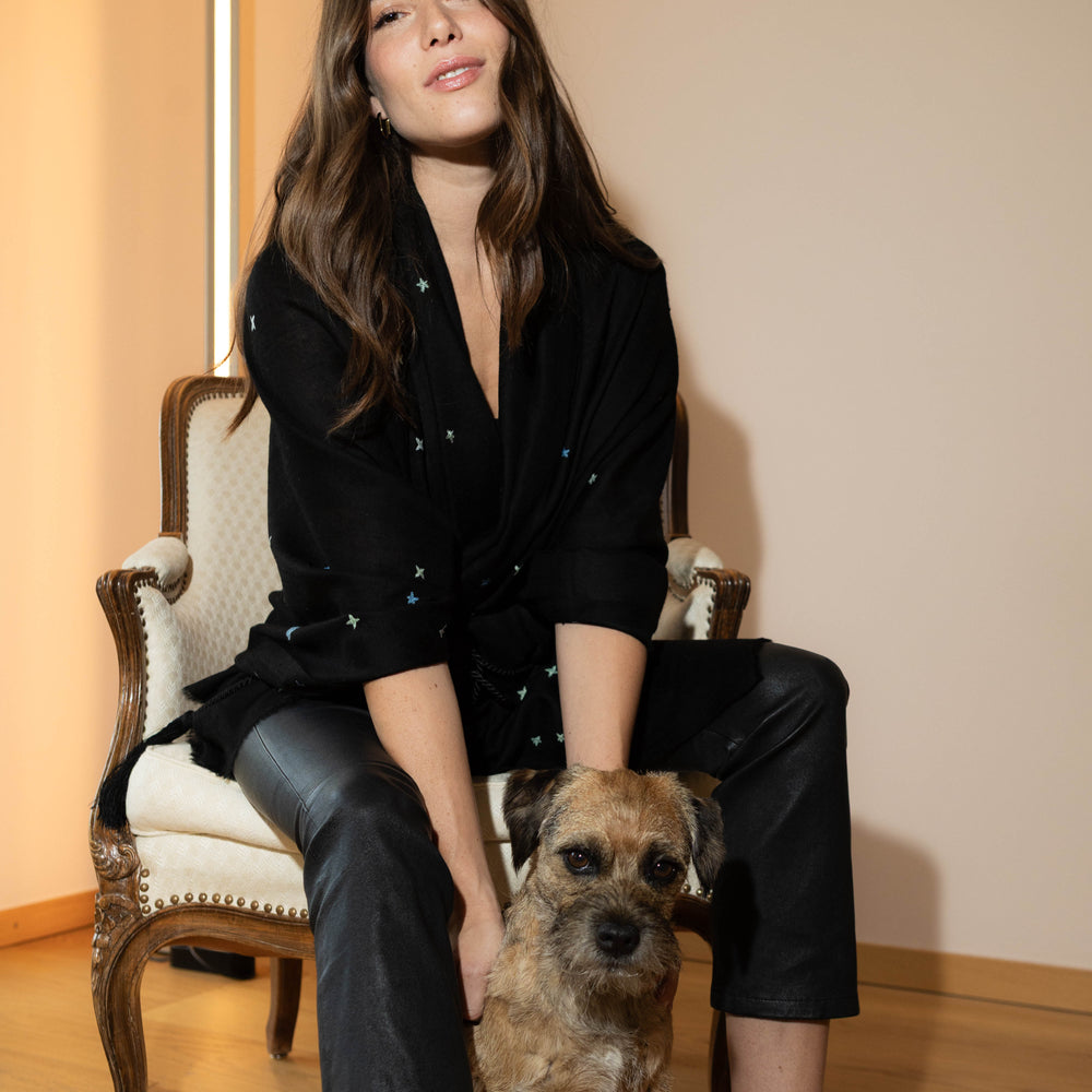 
                      
                        Model trägt den schwarzen Pashmina Schal „The Adorned – Dancing Universe“ mit farbiger Universumsstickerei; handgefertigtes Kaschmir, inspiriert vom mystischen Kosmos
                      
                    