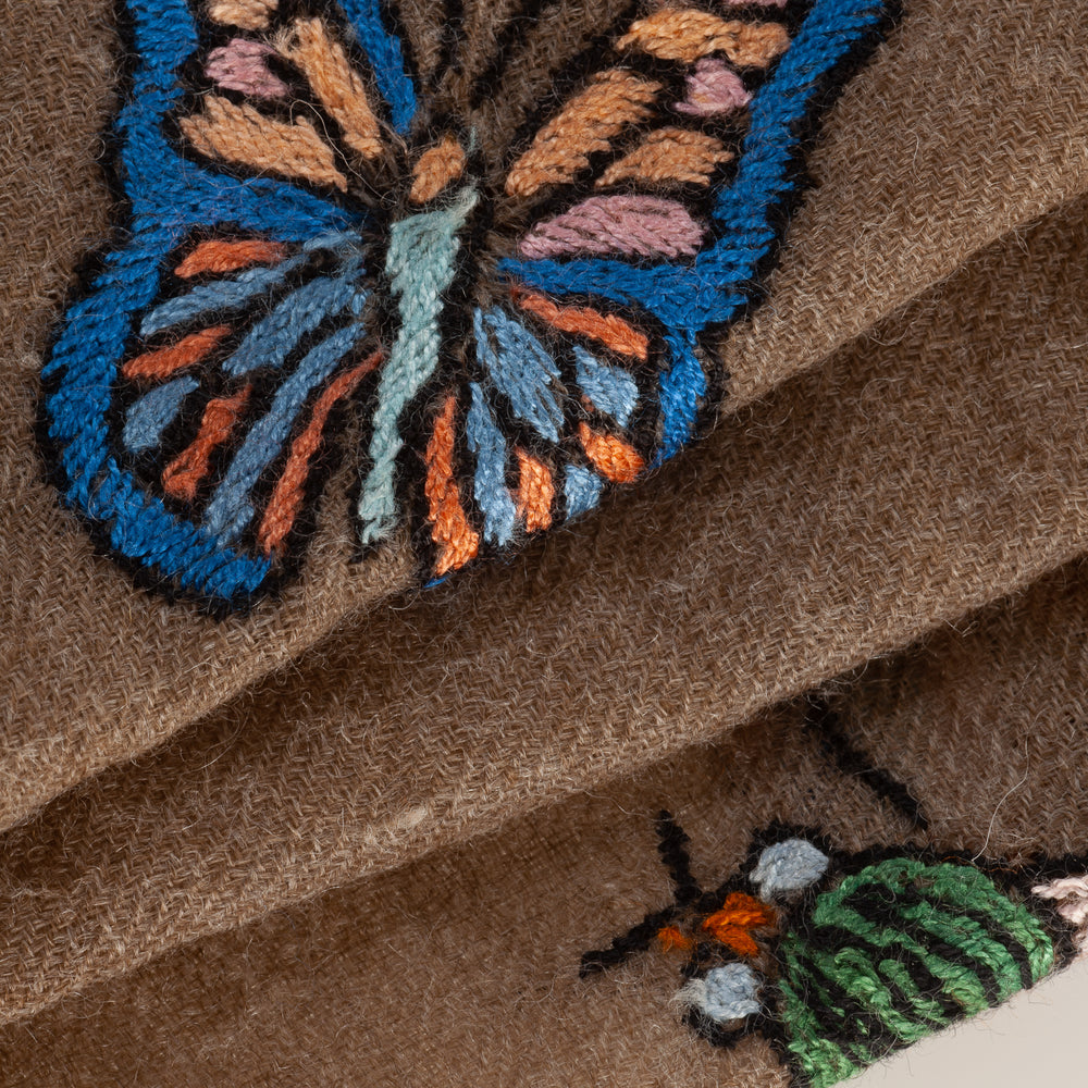 
                      
                        Detailaufnahme der kunstvollen Handstickerei mit bunten Schmetterlingen auf dem Pashmina Schal „The Adorned – Garden Dancers“; meisterhafte Handarbeit aus Kaschmir.
                      
                    