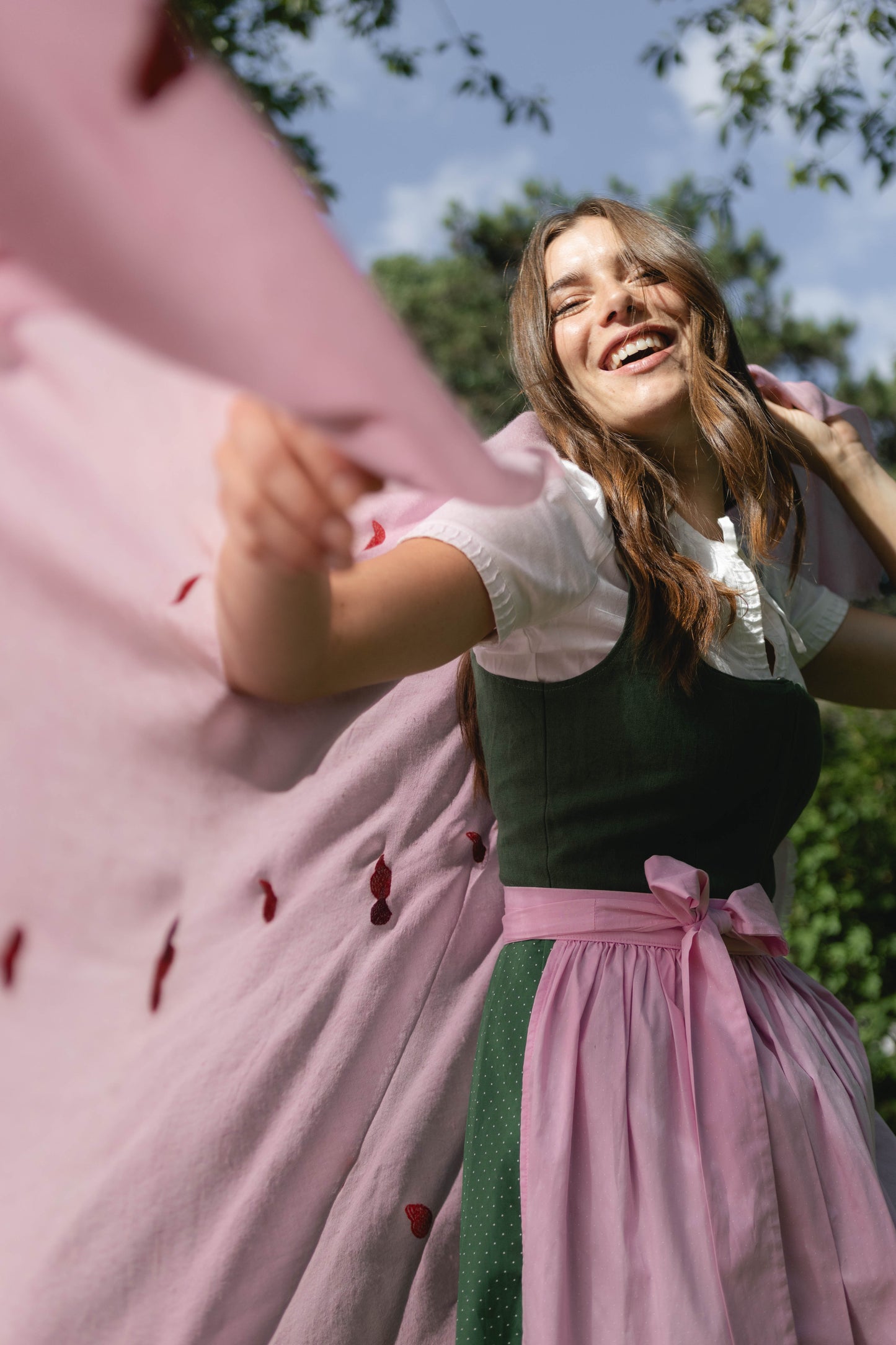 Model trägt den rosa Pashmina Schal „The Adorned – Mei Herzl“ mit roten, handgestickten Herzen; zarter Kaschmir mit verspielter Eleganz.