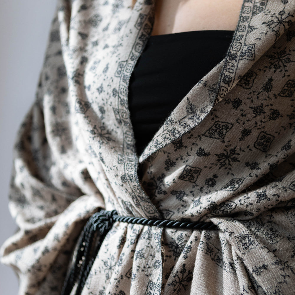 
                      
                        Detailaufnahme mit Model der schwarzen Ornamentstickerei auf dem Pashmina Schal „The Adorned – Musky Tales“; kunstvolle Handarbeit aus reiner Kaschmirwolle.
                      
                    