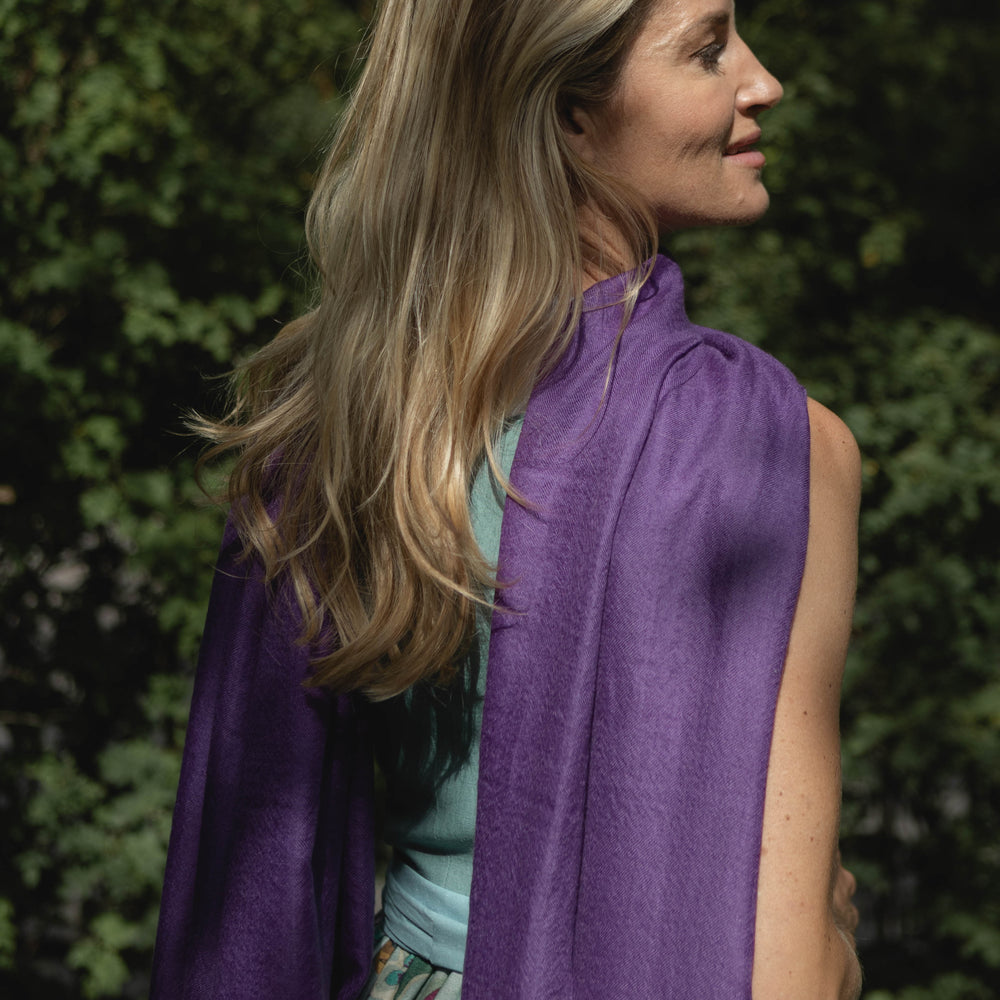 Model trägt den Pashmina Kaschmir Schal „The Breeze – Autumn Amethyst“ in intensivem Amethyst-Lila; luftig, leicht und elegant