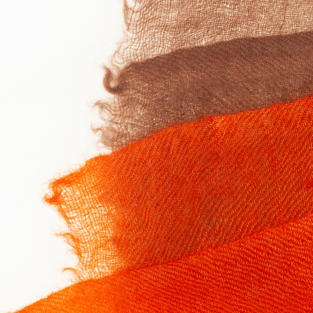 
                      
                        Detail des Ombré-Farbverlaufs in Beige und Orange beim Pashmina Schal „The Breeze – Autumn Ombré“; feine, luftige Gewebestruktur.
                      
                    