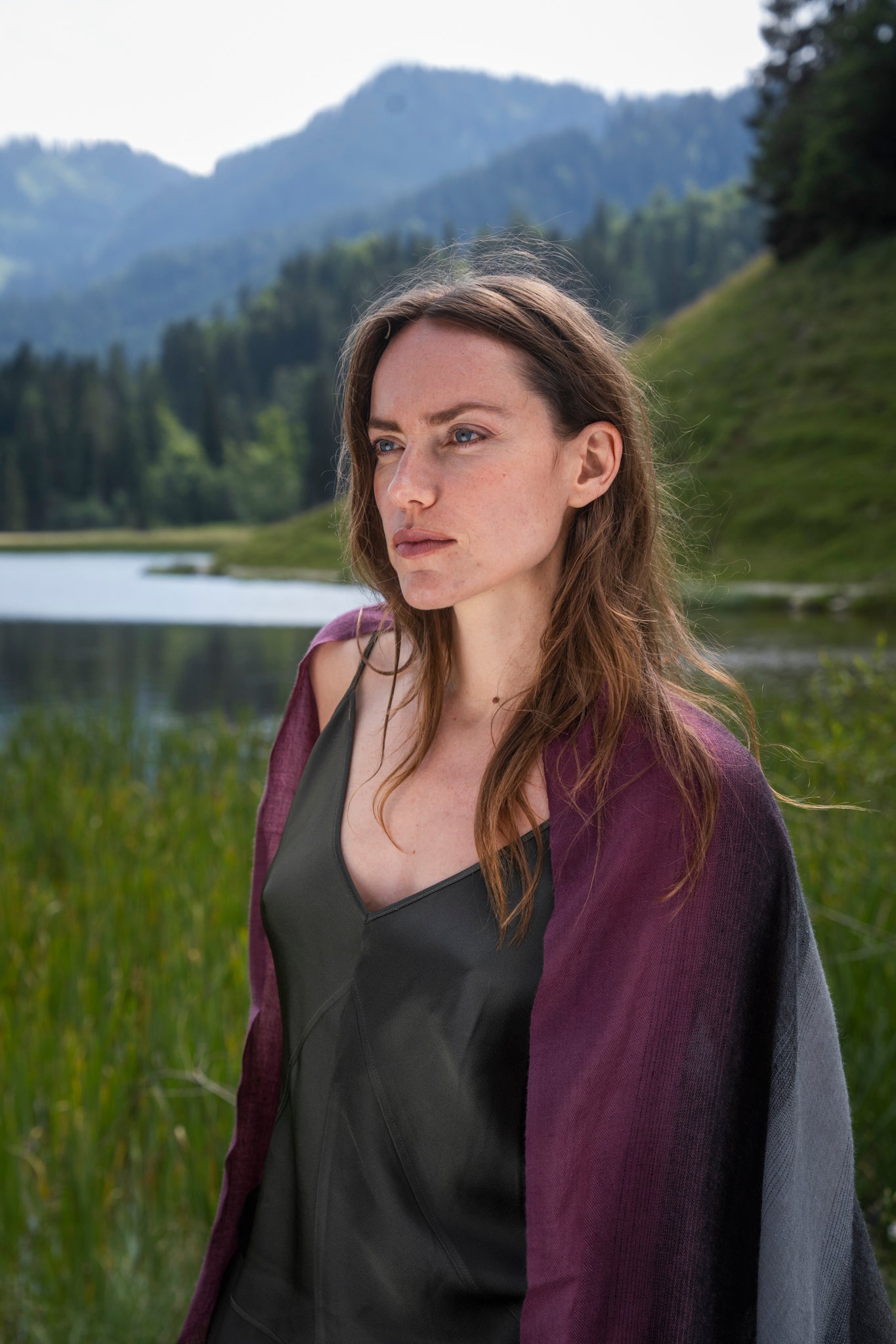 Model trägt den Kaschmir Pashmina Schal „The Breeze – Dusky Vineyard Ombré“ mit elegantem Aubergine-Olive-Grau-Verlauf; leicht und fließend.