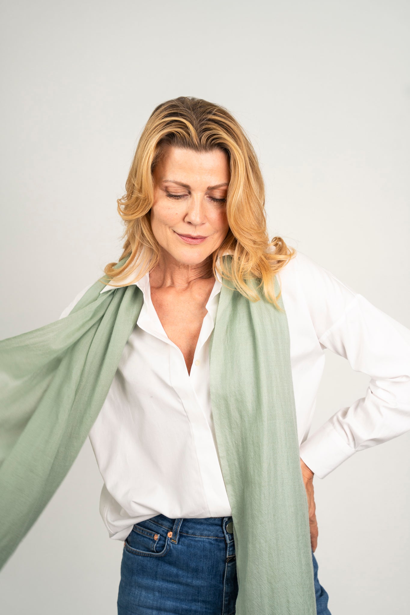 Model trägt den Kaschmir Pashmina Schal „The Breeze – Dusty Mint“ in gedecktem Mintgrün; leicht, fließend und elegant.