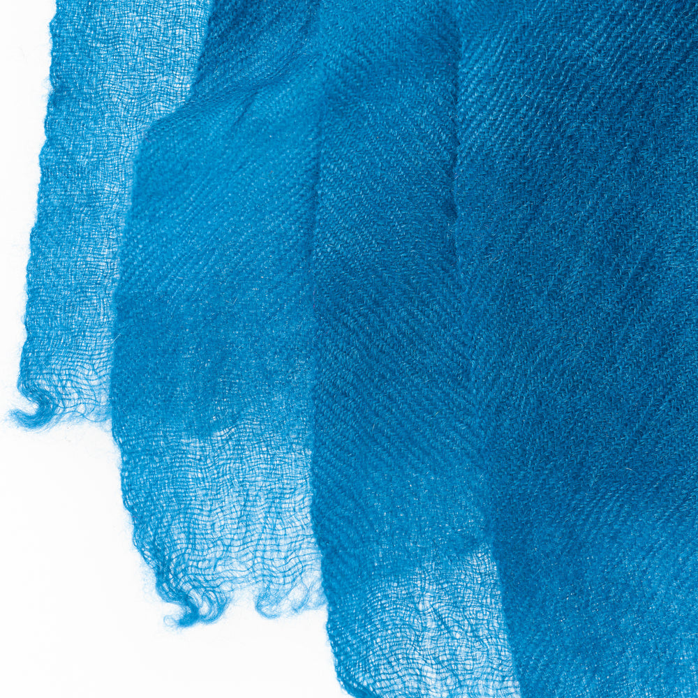 
                      
                        Farbdetail des Pashmina Schals „The Breeze – Ocean Azure“ in gedecktem, dennoch strahlendem Azurblau; feine Gewebestruktur und zarte Verarbeitung.
                      
                    
