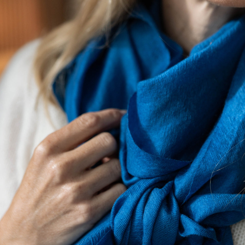 
                      
                        Model trägt den Kaschmir Pashmina Schal „The Breeze – Ocean Azure“ in leuchtendem Azurblau; besonders zart, leicht und elegant.
                      
                    