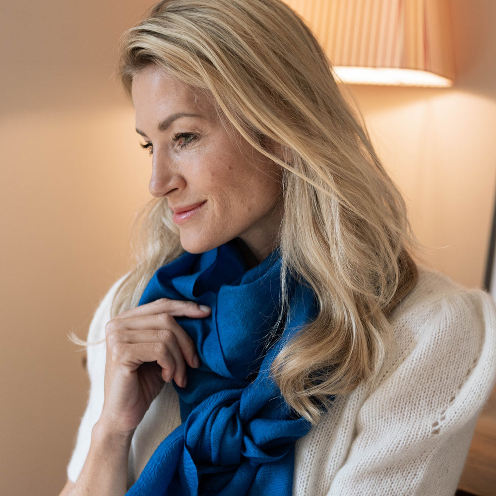 
                      
                        Model trägt den Kaschmir Pashmina Schal „The Breeze – Ocean Azure“ in leuchtendem Azurblau; besonders zart, leicht und elegant
                      
                    