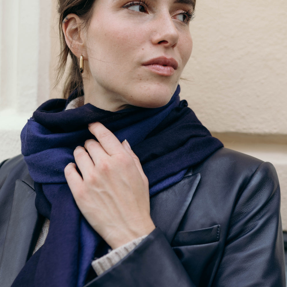 Model trägt den Kaschmir Pashmina Schal „The Breeze – Ombré Indigo“ mit elegantem Nachtblau-Schwarz-Verlauf; leicht, weich und handgefertigt
