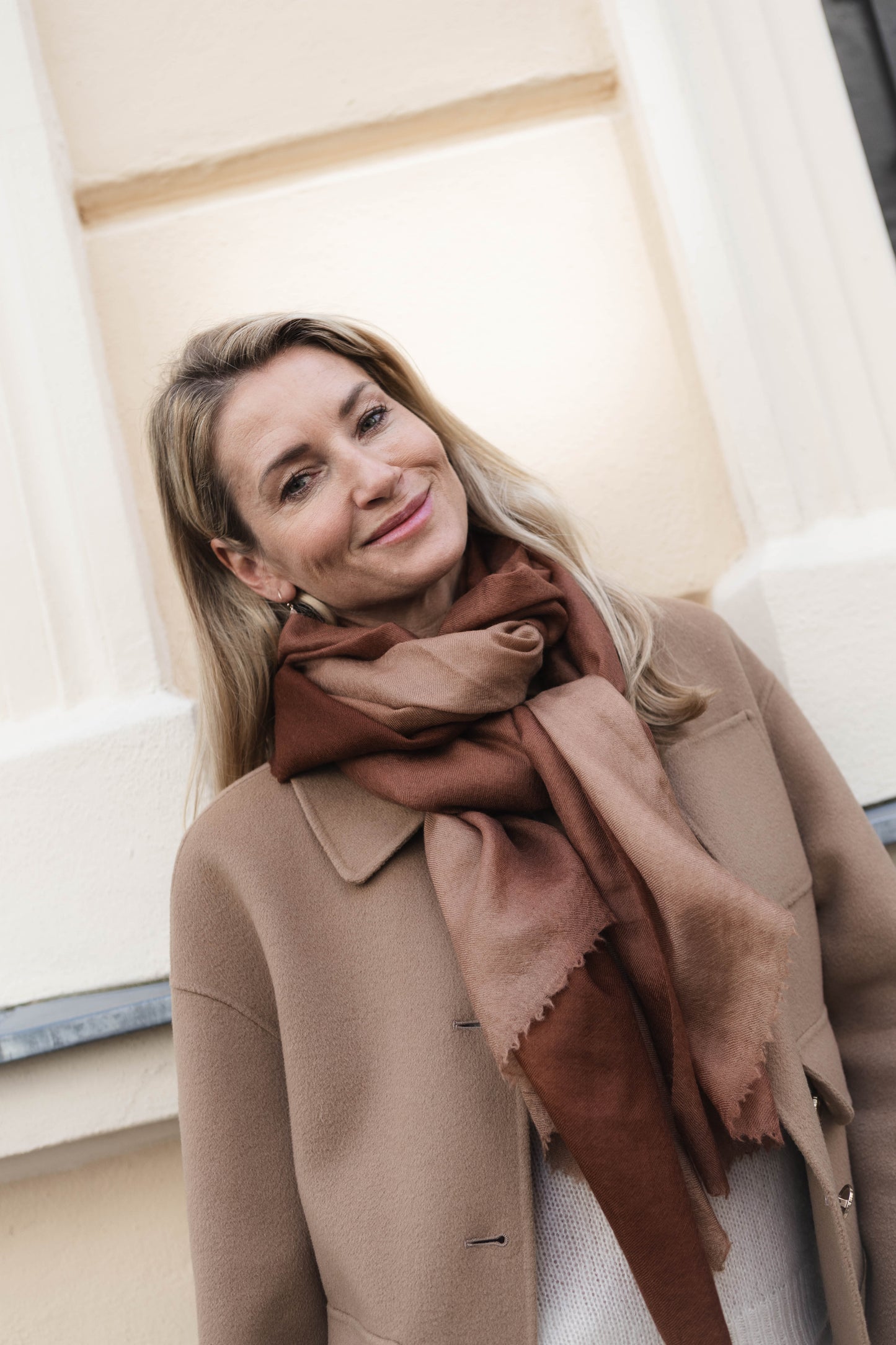 Model trägt den Kaschmir Pashmina Schal „The Breeze – Ombré Toffee“ mit sanftem Toffee-Beige-Verlauf; leicht, fließend und elegant.